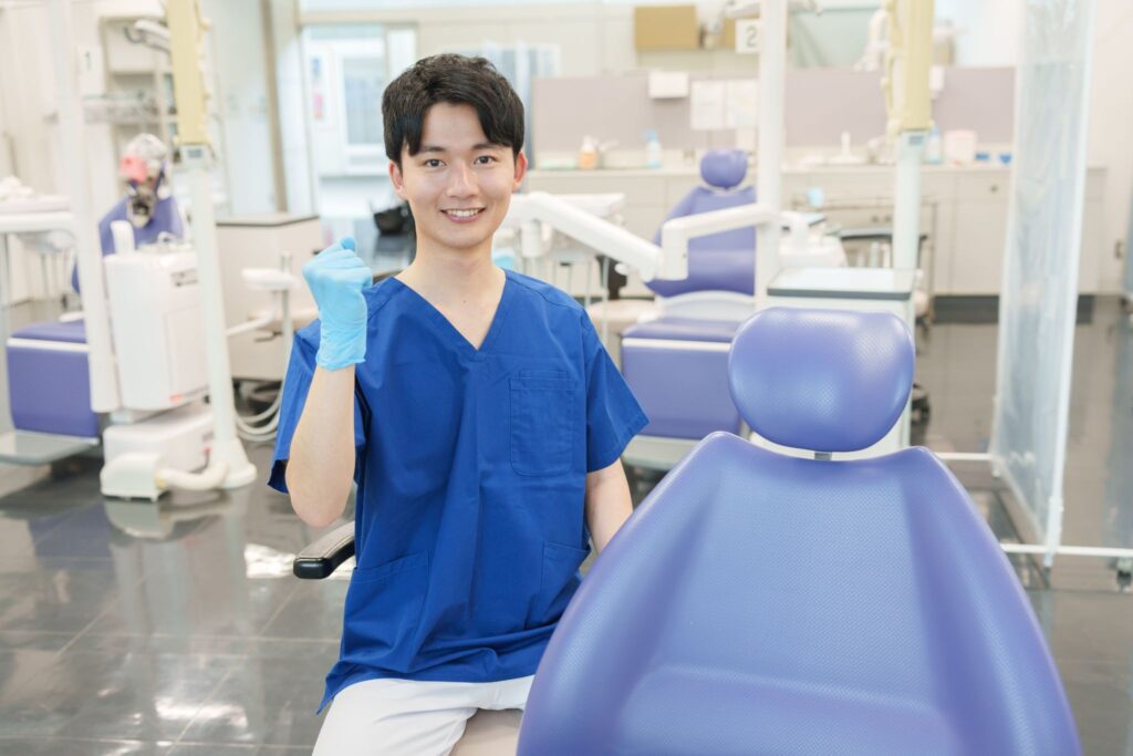 片手をあげてこちらに笑顔を向ける矯正歯科医