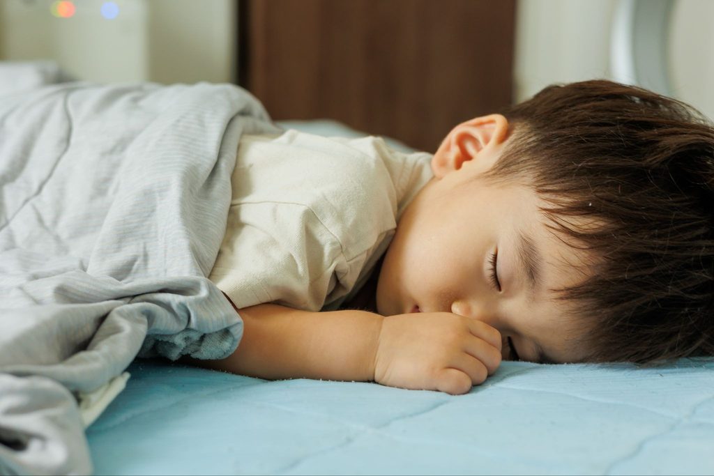 指をしゃぶりながら寝ている子供