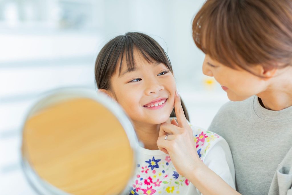 子どもの歯並びを見ている母