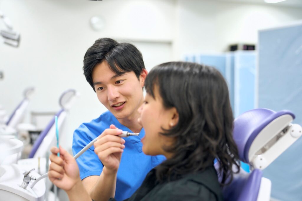 女性の口の中をチェックしている歯科医師