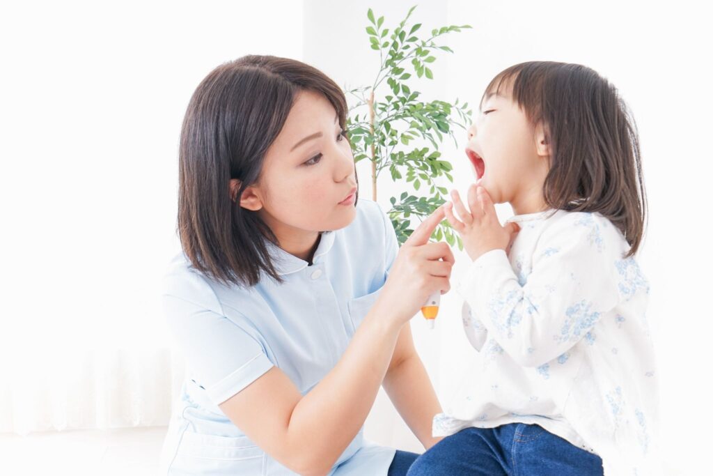 子どもの歯並びをチェックしている歯科医療従事者の女性