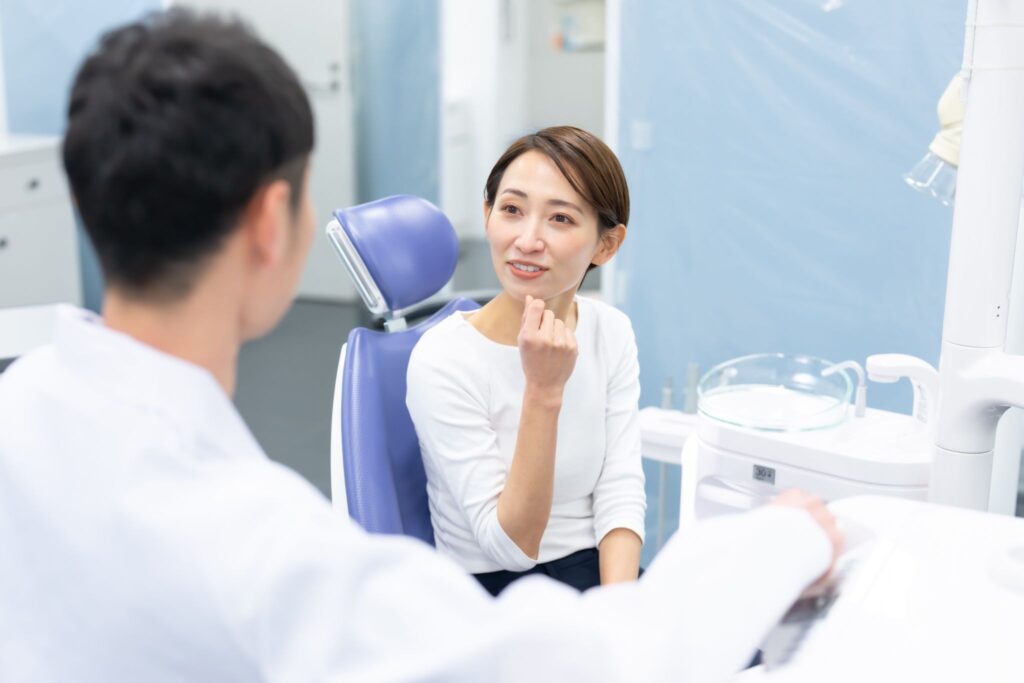 歯列矯正の医療費控除について矯正歯科医に相談している女性