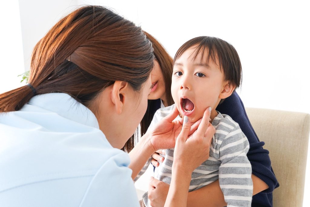 子どもの口の中をチェックしている歯科医療従事者