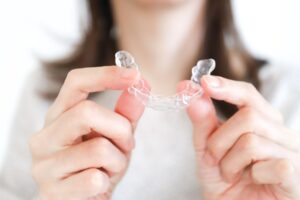 マウスピース型矯正装置を持っている女性の手元